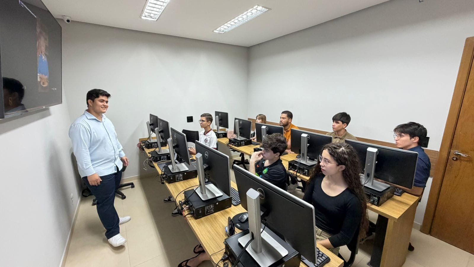Instrutor do Instituto NORD conduzindo uma aula presencial para jovens em estações de computador